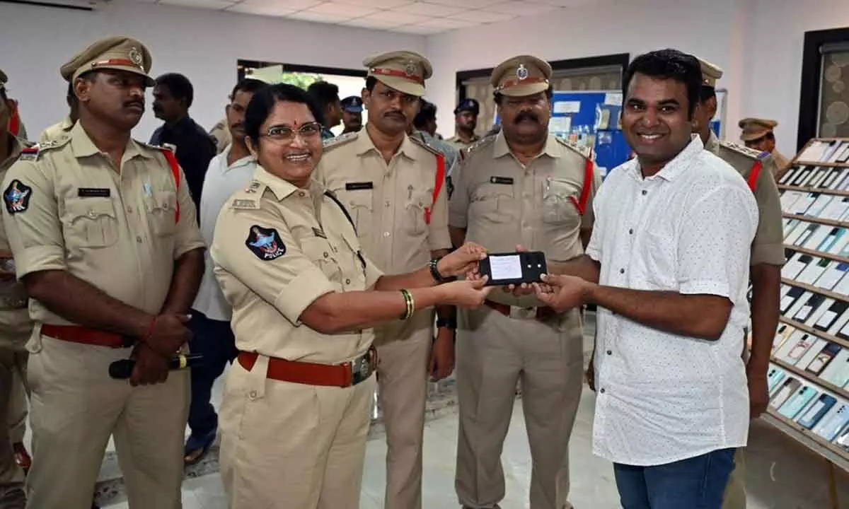 DCP (Crimes) Venkata Ratnam handing over the recovered mobile phone to a person in Visakhapatnam on Sunday