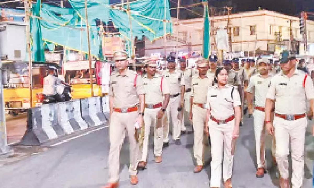 Police officials and staff led by SP G R Radhika taking part in flag march in Srikakulam city on Sunday