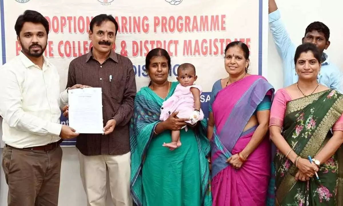 Collector V Prasanna Venkatesh handing over an adopted baby to a couple in Eluru on Thursday