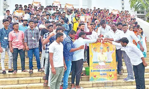 Youth performing ‘Palabhishekam’ to CM N Chandrababu Naidu’s flexi at SV University in Tirupati on Friday.Photo: Pradeep Vennelakanti