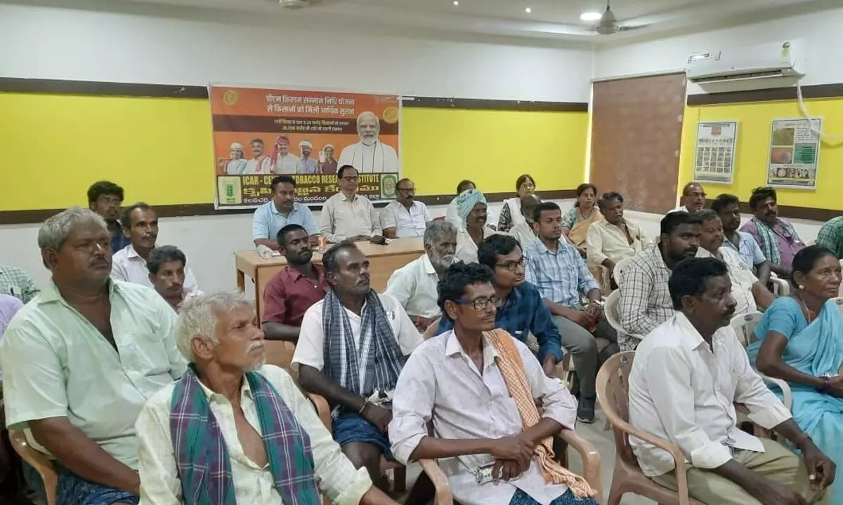 District Agricultural Officer S Madhava Rao watching live telecast of the Kisan Sammelan programme held at Varanasi from PACCS in Kalavacharla of Rajanagaram mandal  along with farmers on Tuesday
