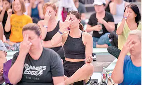 People perform yoga during a programme organised to celebrate the 10th International Day of Yoga, at Times Square, in New York on Thursday