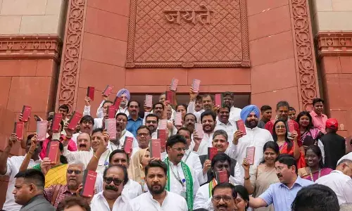 Opposition MPs show copies of the Constitution of India at the Parliament House complex on the first day of the first session of the 18th Lok Sabha, in New Delhi on Monday