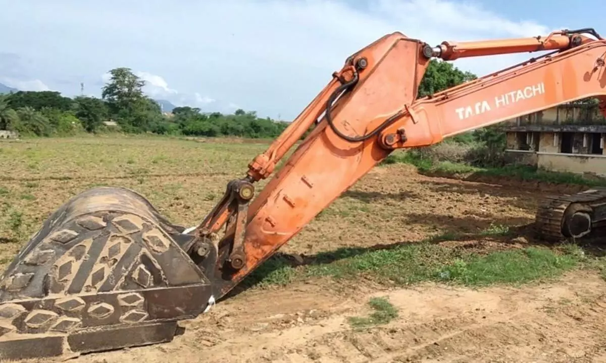 Earth mover parked on the banks of Vamsadhara river for digging sand