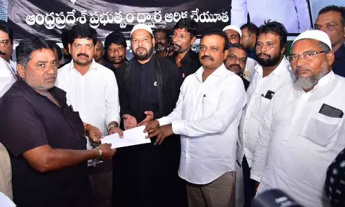 Minister Kollu Ravindra and MP V Balashouri handing over financial assistance of Rs 5,000 to a Muzavar in Machilipatnam on Sunday
