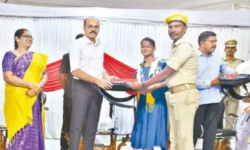 Prakasam SP Garud Sumit Sunil presenting scholarship and commendation certificate to daughter of a home guard in Ongole on Sunday