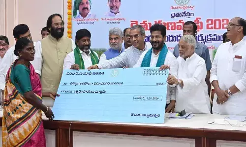Chief Minister A Revanth Reddy along with senior leaders presenting a check to a beneficiary during the launch of farmers loan waiver scheme at Secretariat, in Hyderabad on Thursday
