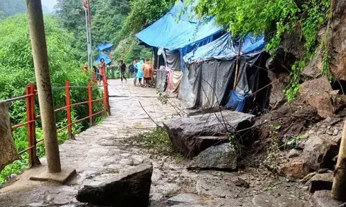 Debris lies on a road following a landslide on the Kedarnath trekking route, in Rudraprayag district on Sunday