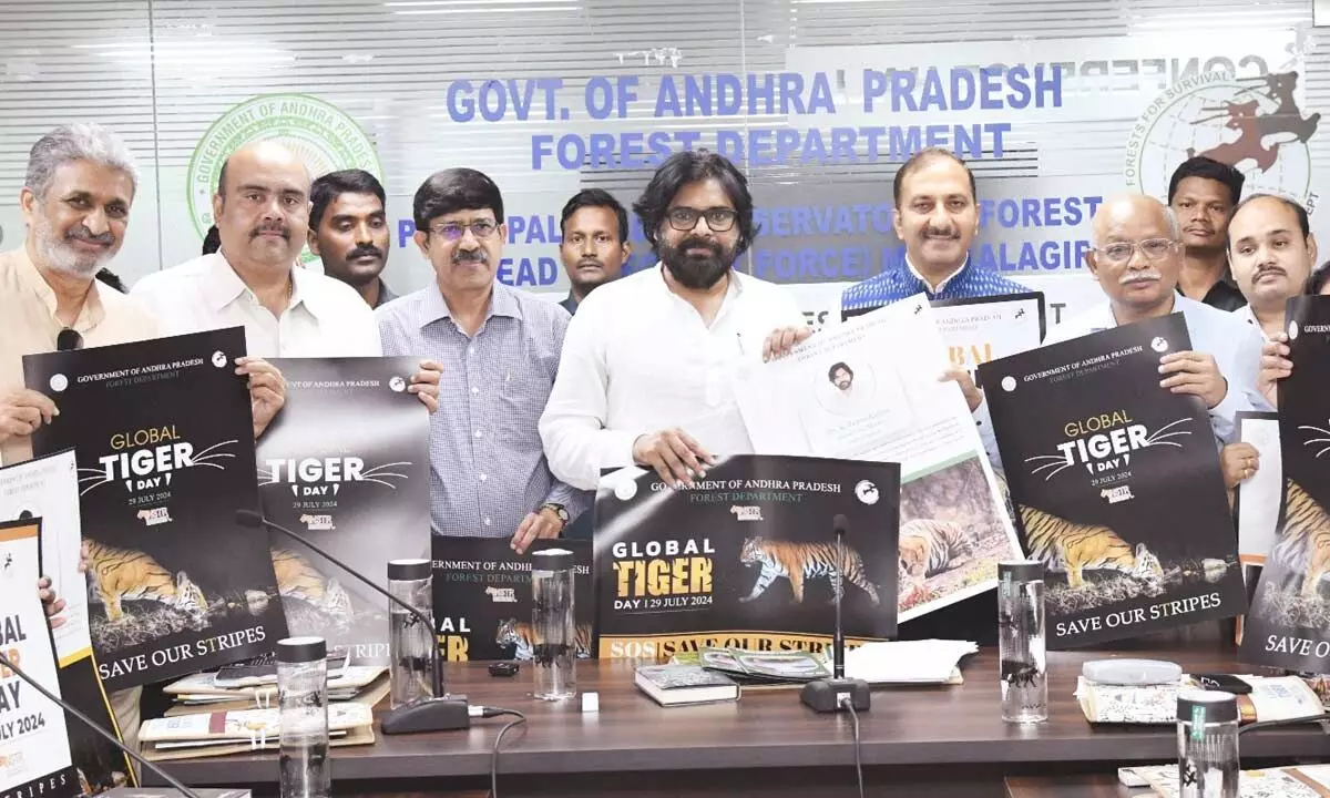 Deputy Chief Minister and environment and forests minister Pawan Kalyan releasing a poster on International Tiger Day at Aranya Bhavan in Mangalagiri on Monday