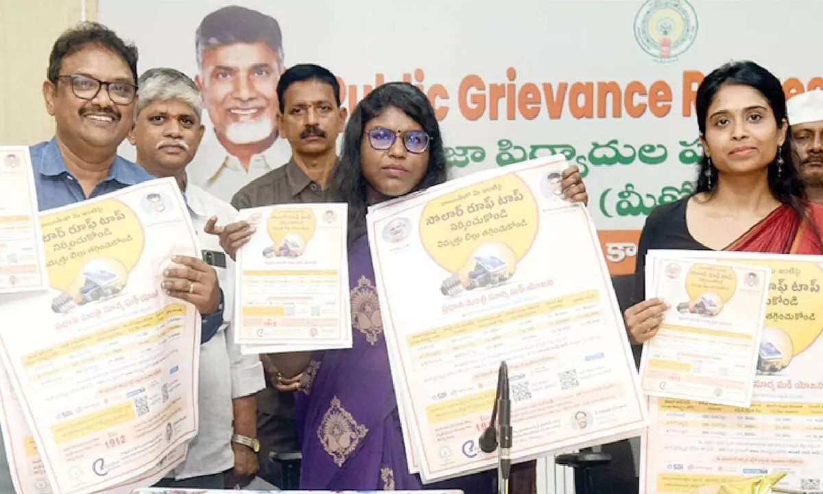 Collector K Vetri Selvi along with officials releasing wall poster and brochure on solar panel rooftops in Eluru on Monday