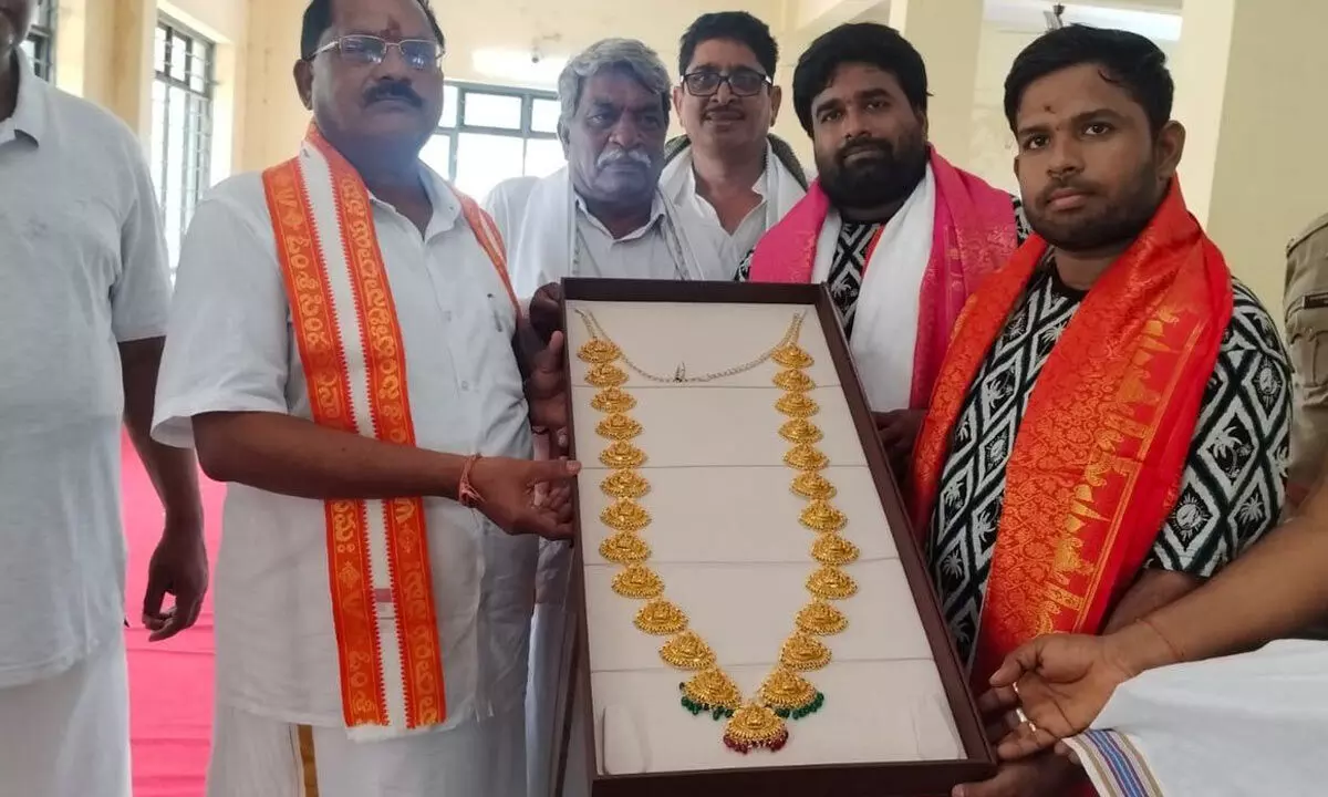 Vizag based devotee donating a gold haaram to temple executive officer S Srinivasa Murthy in Visakhapatnam on Monday.