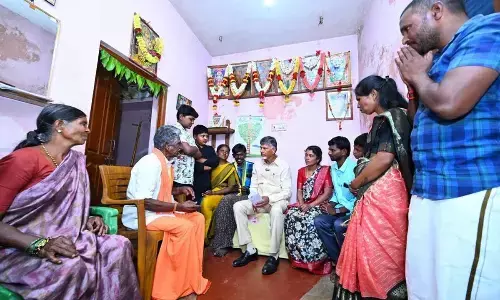 Chief Minister N Chandrababu Naidu interacts with a family after distributing pension at Gundumala village in Sri Sathyasai district on Thursday
