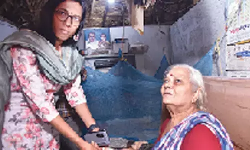 Guntur District Collector S Nagalakshmi distributing pension to a beneficiary in Guntur on Thursday