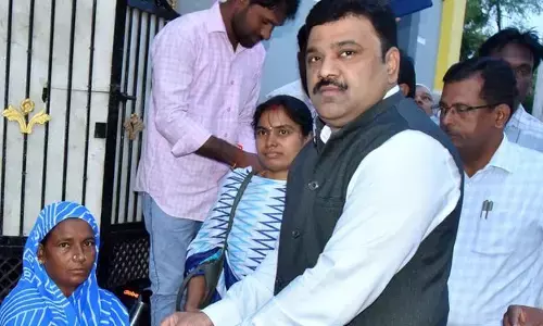 District Collector P Ranjit Basha handing over pension amount to Mastan Bi at Chinna Tekur village in Kallur mandal on Thursday