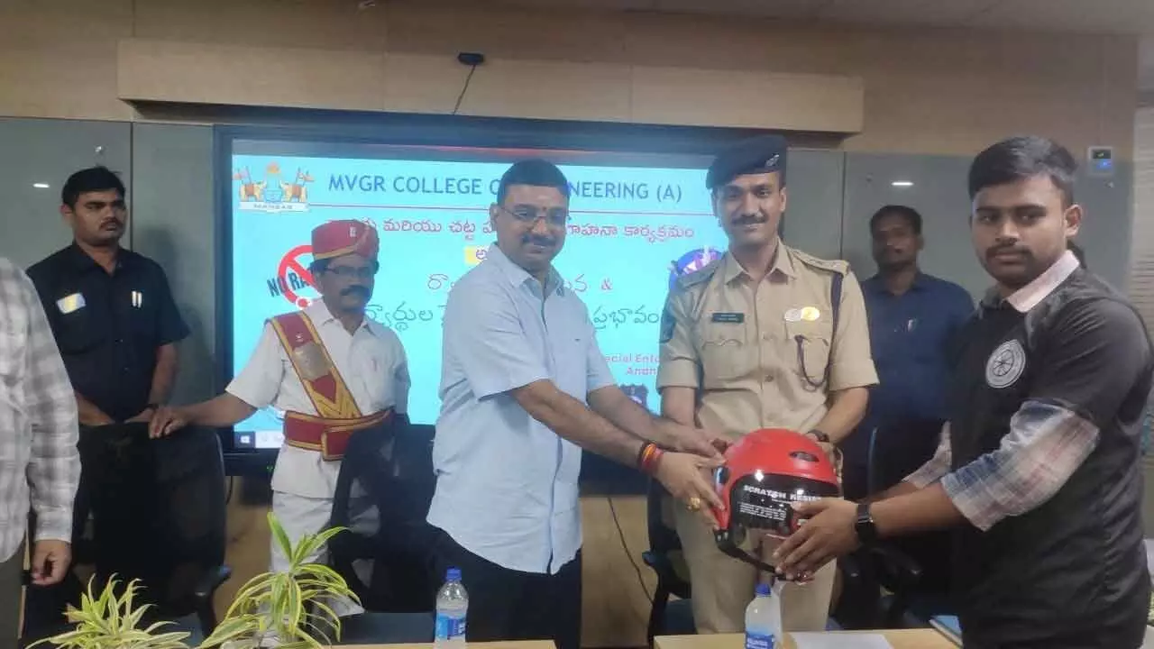 Principle district judge Sai Kalyan Chakravarthi and SP Vakul Jindal distributing helmets to students at MVGR College of Engineering on Thursday