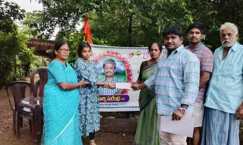 One of the deceased family members receiving a compensation cheque on Friday