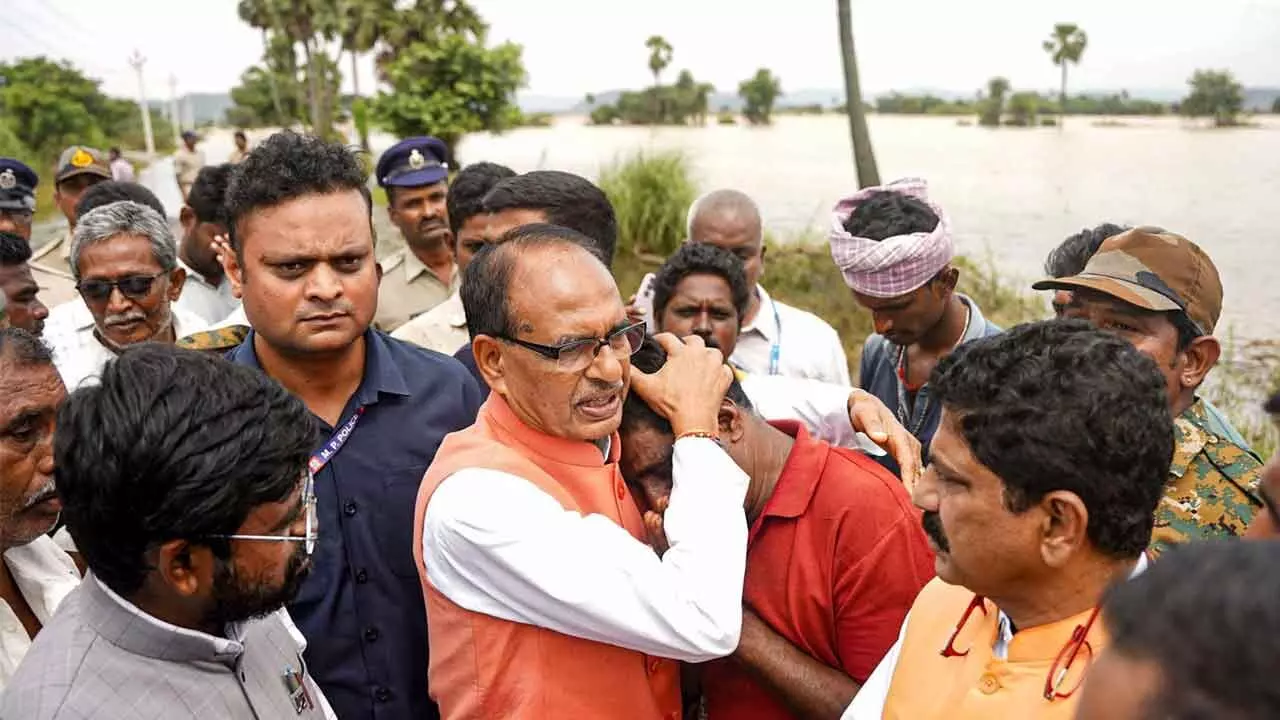 Union Agricultural Minister Shivraj Singh Chouhan consoles an affected person during his visit to the flood-affected areas to assess the crop damage, in Kesarapalle