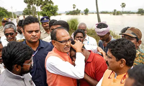 Union Agricultural Minister Shivraj Singh Chouhan consoles an affected person during his visit to the flood-affected areas to assess the crop damage, in Kesarapalle