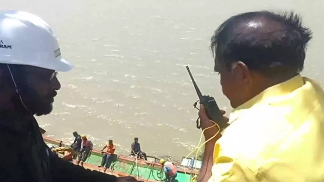 Irrigation minister Nimmala Ramanaidu speaks to workers involved in retrieval of boats from Prakasam barrage on Thursday