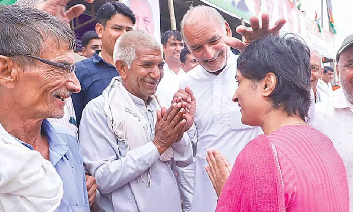 Former wrestler and Congress candidate from Julana constituency Vinesh Phogat greets locals while campaigning for the upcoming Haryana Assembly elections, in Jind district