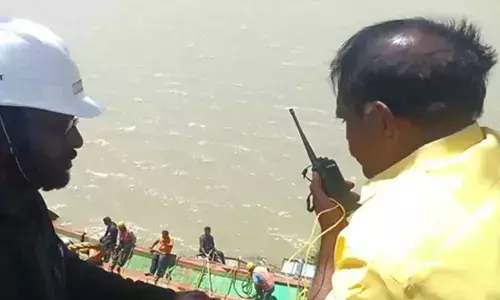 Irrigation minister Nimmala Ramanaidu speaks to workers involved in retrieval of boats from Prakasam barrage on Thursday