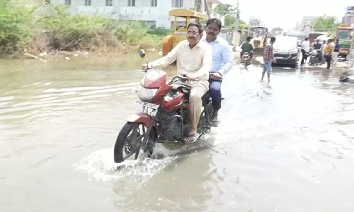 Municipal Administration and Urban Development Minister P Narayana visits food-affected areas in Vijayawada on motorcycle to monitor draining of water, on Friday