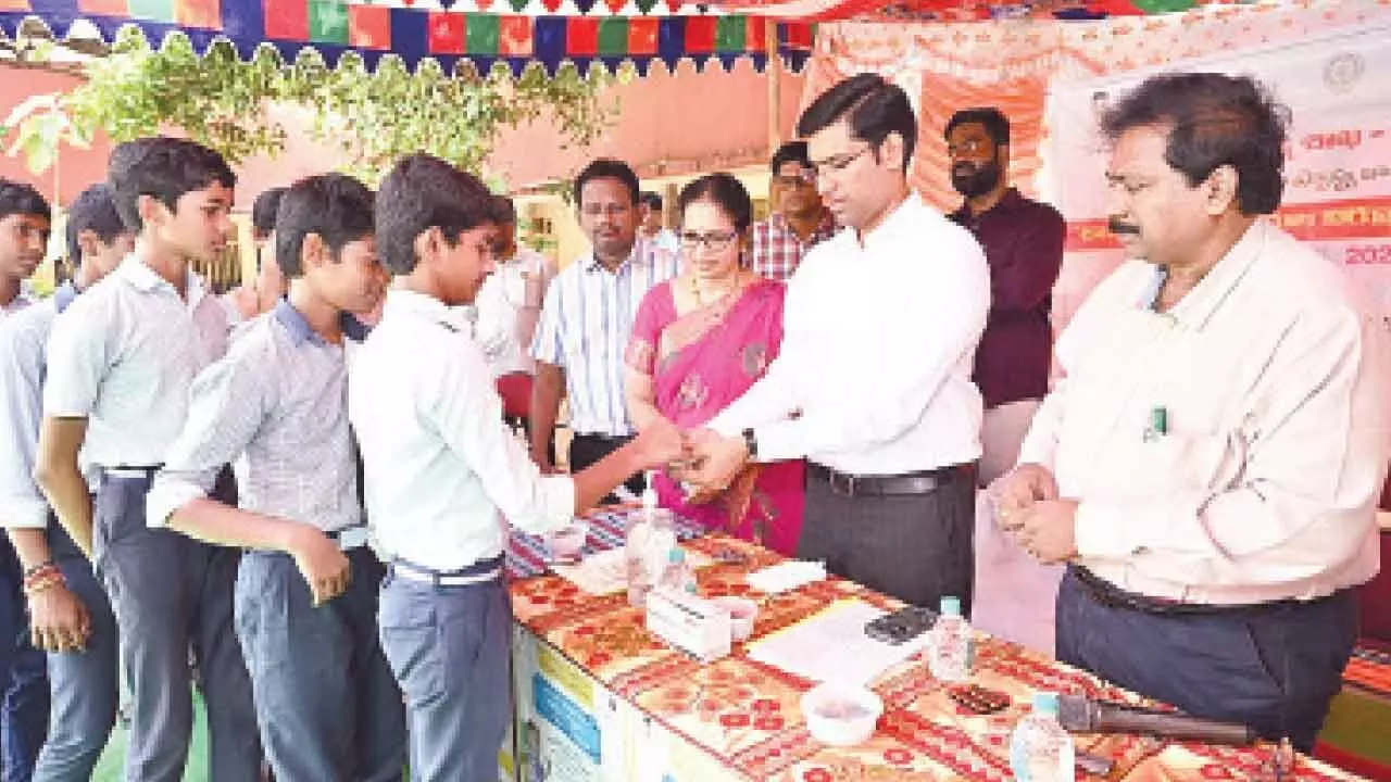 District Collector Dr S Venkateswar giving Albendazole tablets to schoolchildren in Tirupati on Tuesday. DM&HO Dr U Sreehari is also seen.