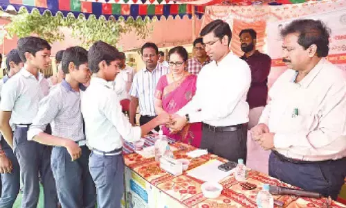 District Collector Dr S Venkateswar giving Albendazole tablets to schoolchildren in Tirupati on Tuesday. DM&HO Dr U Sreehari is also seen.