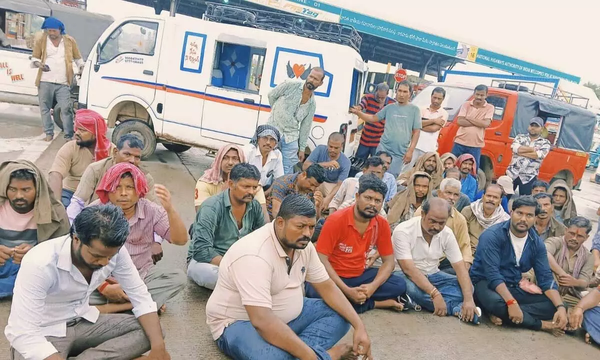 Four-wheeler and cab drivers stage an agitation in front of toll gate at Karapadu on Friday