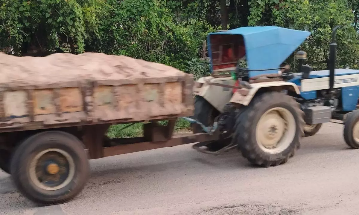 Sand is being transported by tractors in the early hours