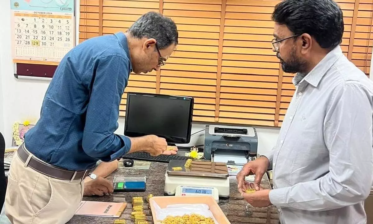 Smart  Creations representatives examining and weighing the gold; EO Bhaskar Rao is seen in  the photo