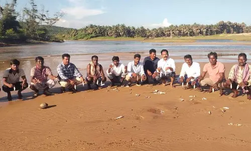 Fishermen staging a protest as dead fish gets washed ashore at Upputeru, Nakkapalli mandal in Anakapalli district