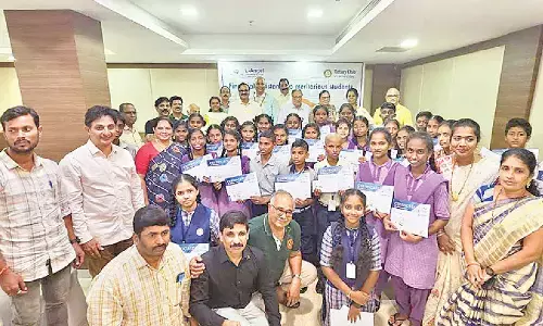 Organisers with meritorious poor students at a scholarship distribution programme held in Visakhapatnam on Sunday