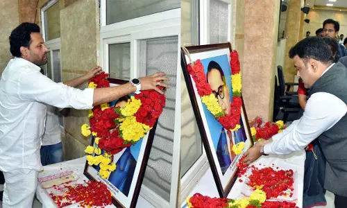 Minister of Industries, Commerce and Food Processing T G Bharath (left) and District Collector P Ranjith Basha paying floral tributes to the portrait of Dr BR Ambedkar on the occasion of the 75th Constitution Day in Kurnool on Tuesday
