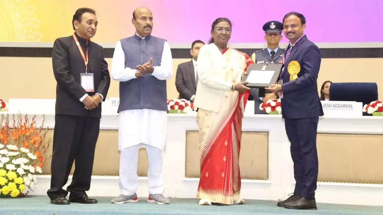 Samagra Shiksha State Project Director B Srinivasa Rao receiving the award from  President Droupadi Murmu