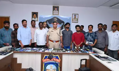 East Godavari district SP D Narasimha Kishore displaying the recovered phones with their rightful owners at a special programme