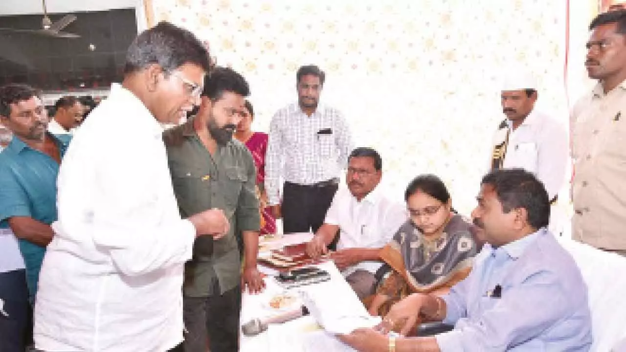 Minister DSBV Swamy receiving petitions from the public at the Revenue Sadassu organised in Valluru of Tangutur mandal on Tuesday