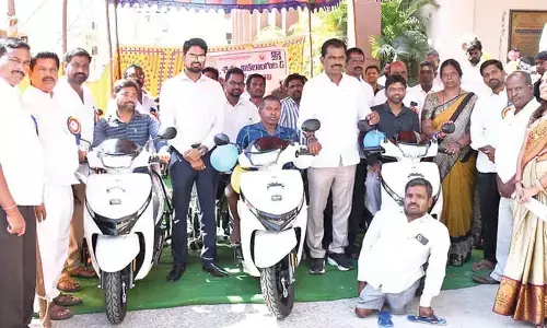 MLA distributes tricycle scooters to disabled