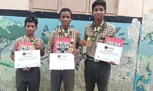 Students showcasing the India Book of Records certificates and medals at the Gurukulam campus in Anakapalli