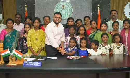 Children’s Home girls tie rakhis to collector