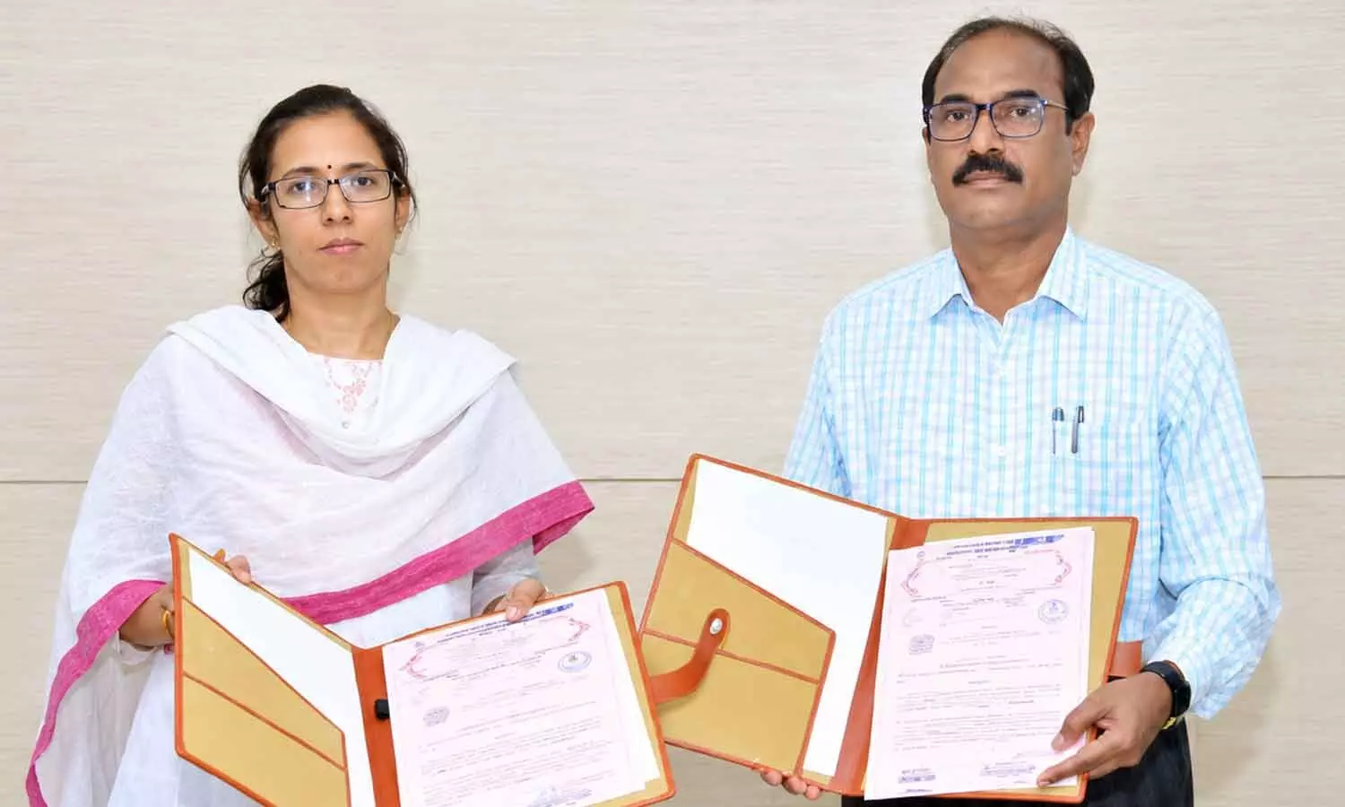 APSECM CEO S Nagalakshmi and JNTUA registrar Prof B Durga Prasad exchange MoU documents in Vijayawada on Monday APSECM CEO S Nagalakshmi and JNTUA registrar Prof B Durga Prasad exchange MoU documents in Vijayawada on Monday
