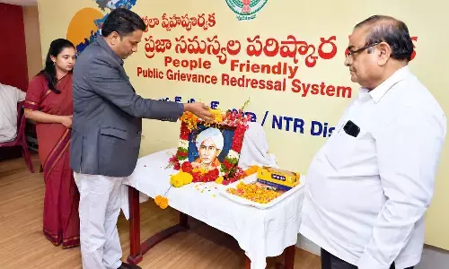 Collector Dr G Lakshmisha paying floral tributes to Gurajada Venkata Apparao at the Collectorate in Vijayawada on Monday