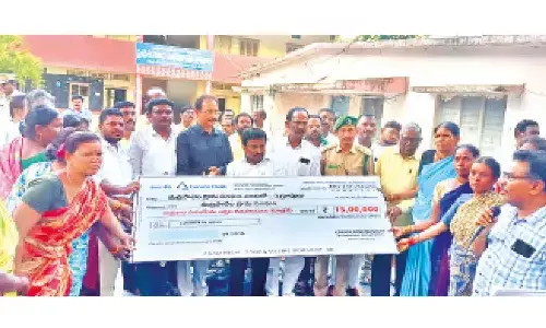 ST Commission Member P Venkatappa distributing cheques to SHGs in Marripalem of Dornala mandal on Wednesday