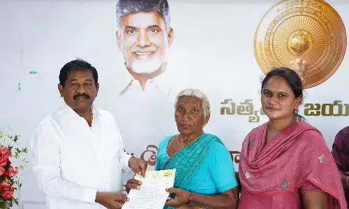 Minister Dr DSBV Swamy distributing CMRF cheques to beneficiaries in Turpu Naidupalem on Sunday