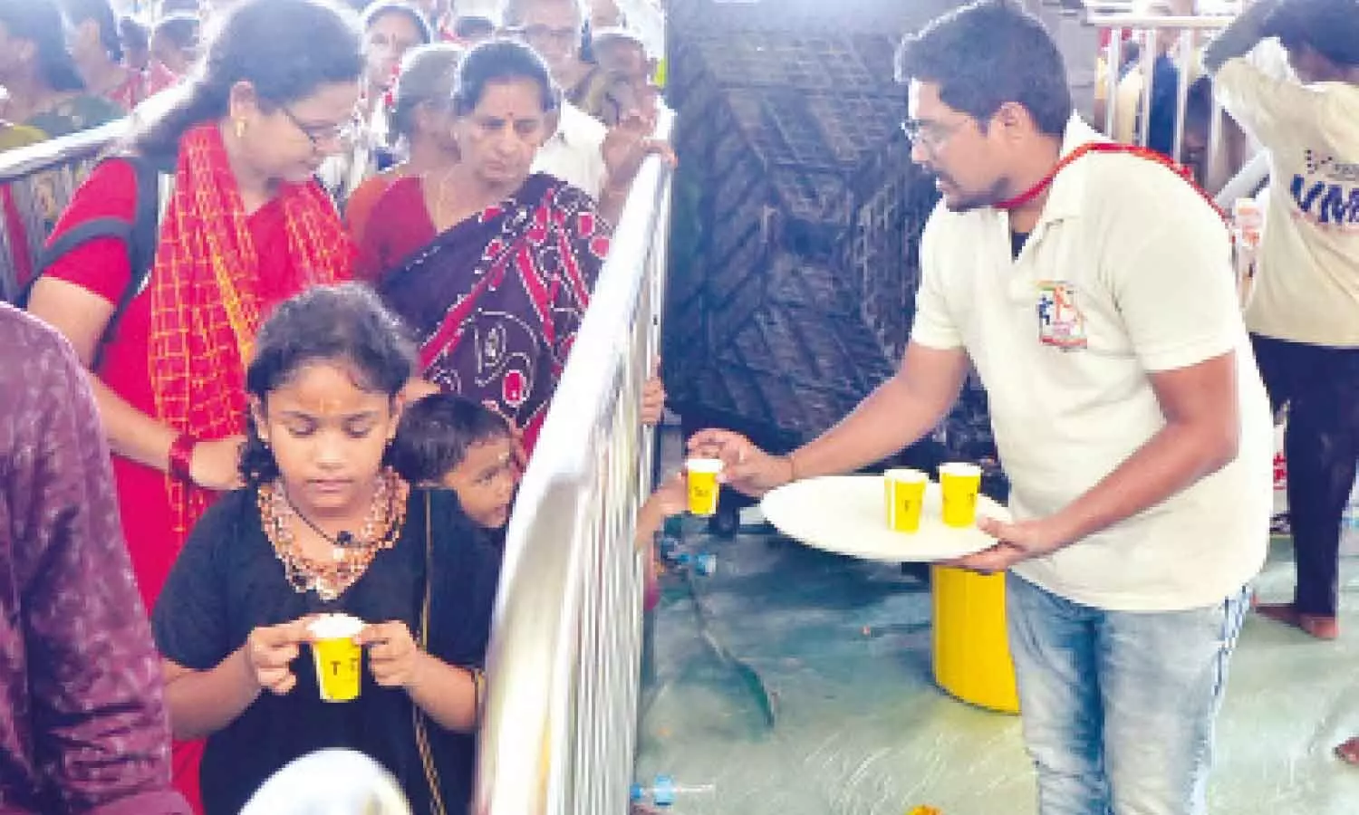 A NSS volunteer distributing tea to devotees waiting in queue lines at Kanaka Durga temple atop Indrakeeladri A NSS volunteer distributing tea to devotees waiting in queue lines at Kanaka Durga temple atop Indrakeeladri