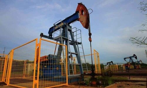 Oil prices dip on record U.S. output, but global market tense