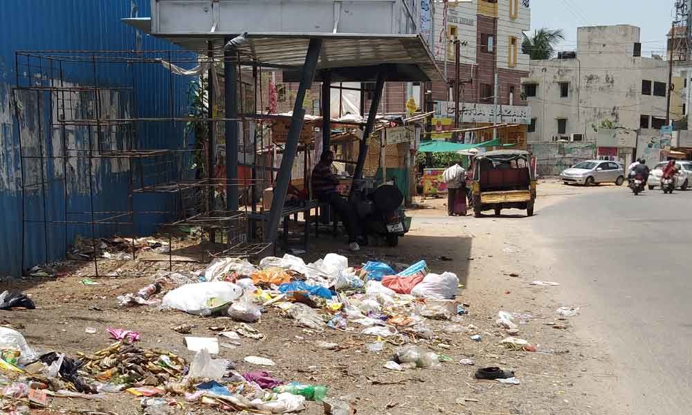 Garbage heaps right beside bus stop