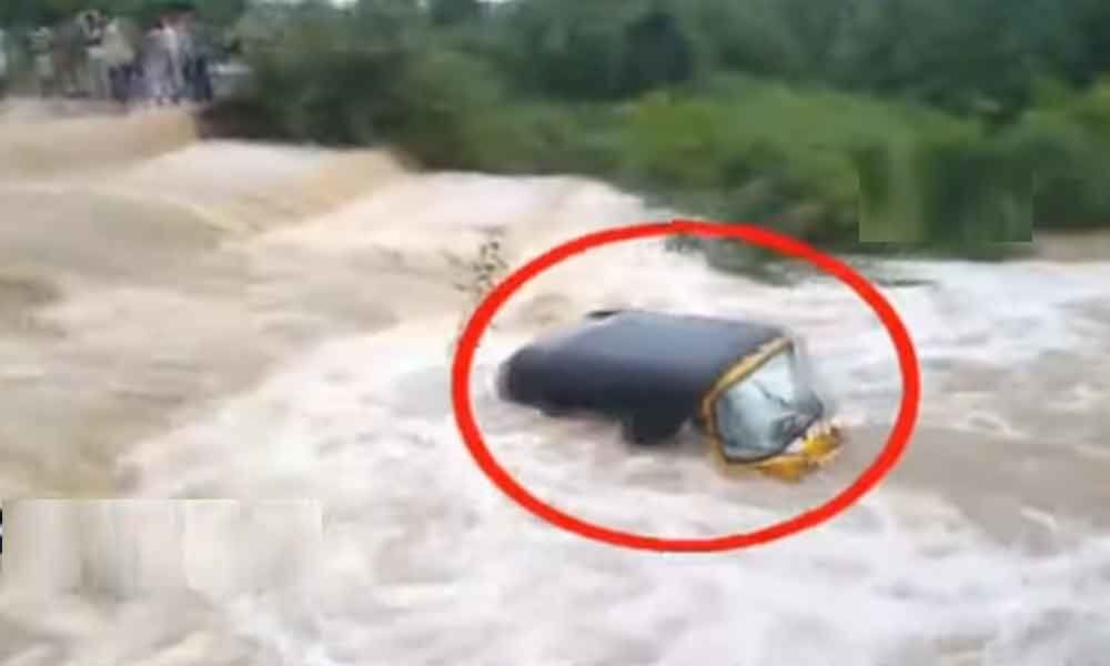 Auto swept away in flash flood after heavy rain at Asifabad