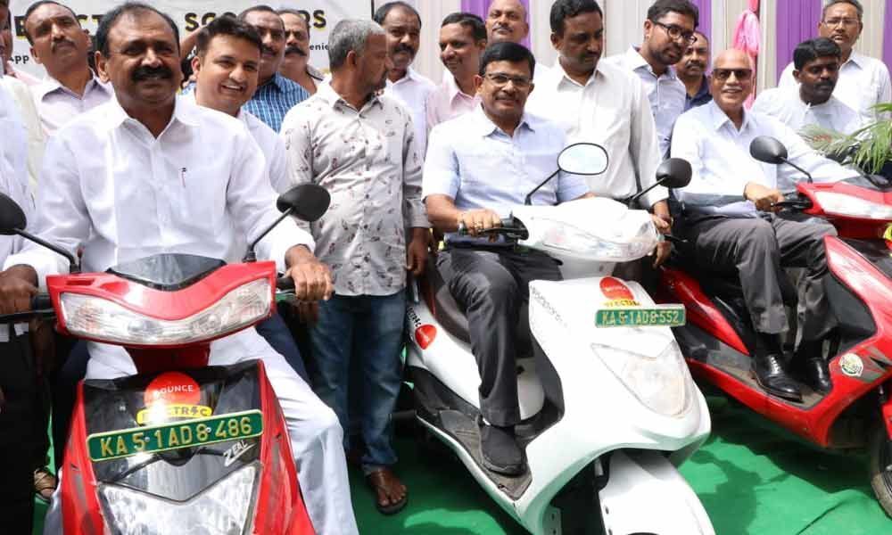Tirupati MLA B Karunakar Reddy and others with the electric scooters in Tirupati on Friday