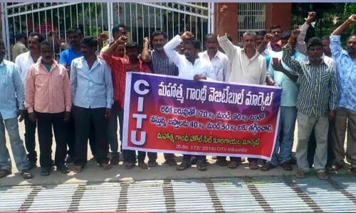 Hamalis overburdened with heavy vegetable bags in Karimnagar